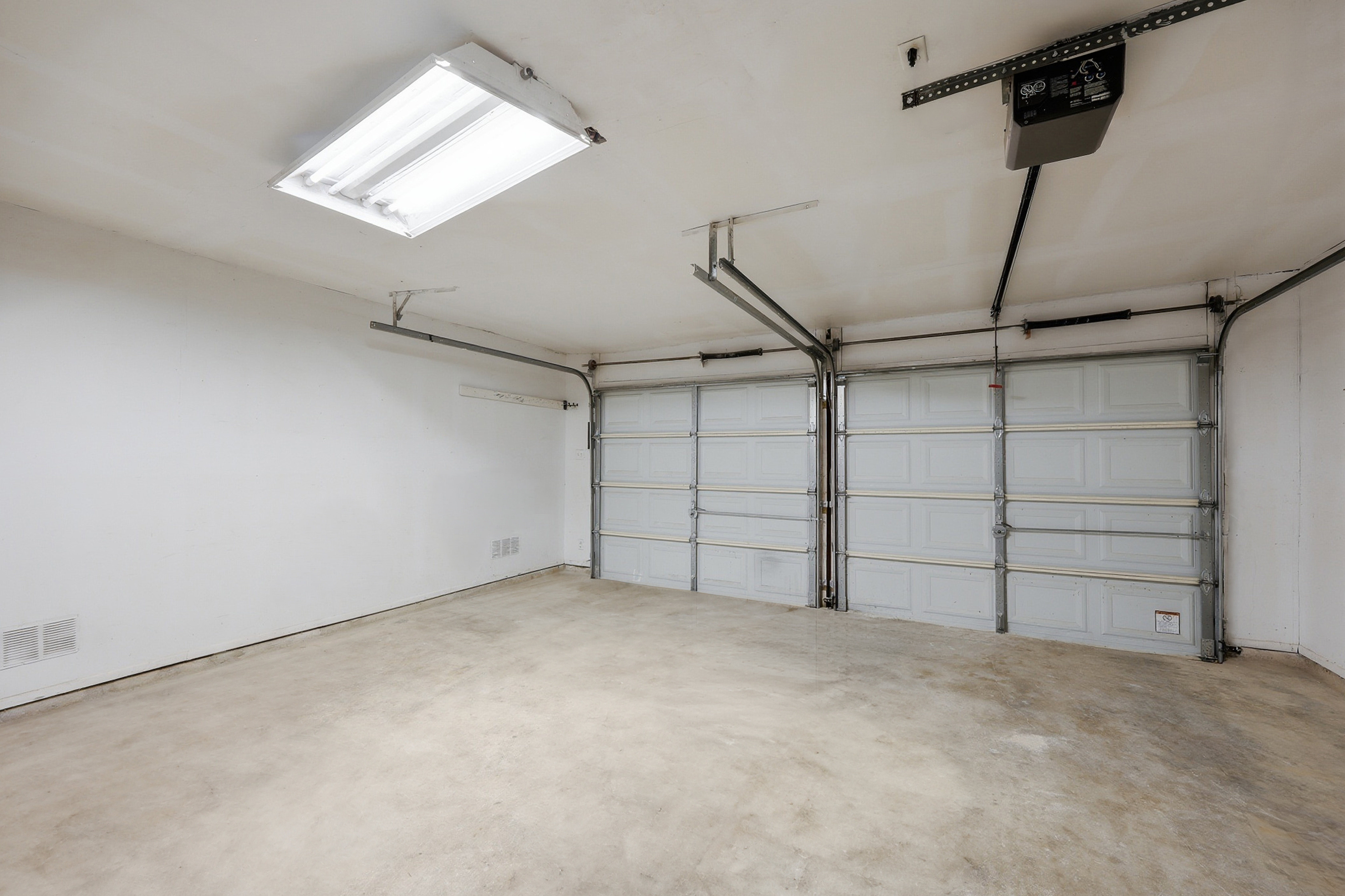 Clean 2-car attached garage with automatic openers and overhead lighting